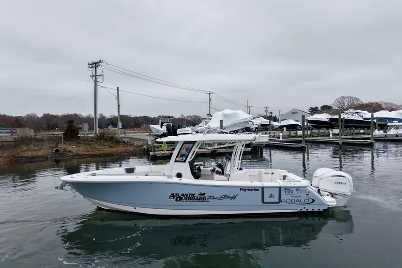  Yacht Photos Pics 2025 Robalo R300 Center Console boat docked in a marina, overcast sky.