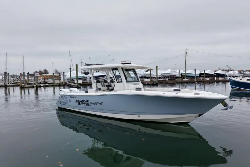  Yacht Photos Pics 2025 Robalo R300 Center Console boat docked in a marina, overcast sky.