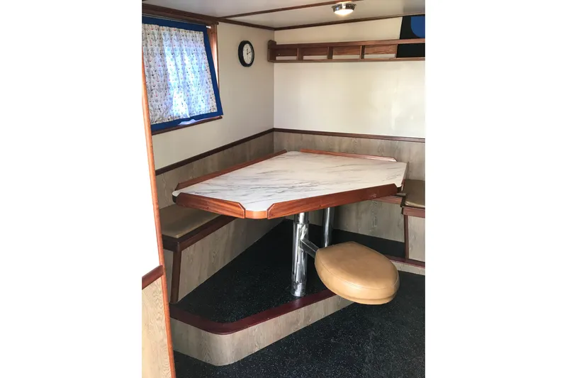  Yacht Photos Pics Interior of 1973 Custom 58&rsquo; Steel Marco Seiner with a cozy dining area and window.