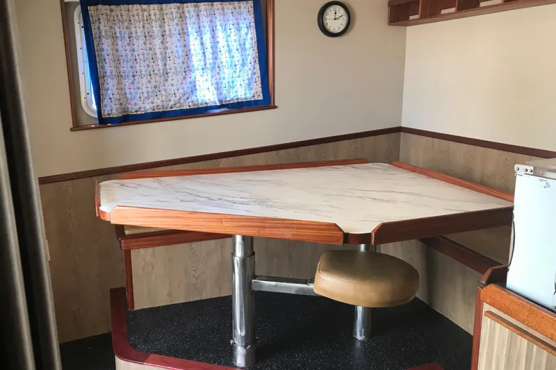  Yacht Photos Pics Dining area in a 1973 Custom 58&rsquo; Steel Marco Seiner with a triangular table and nautical decor.