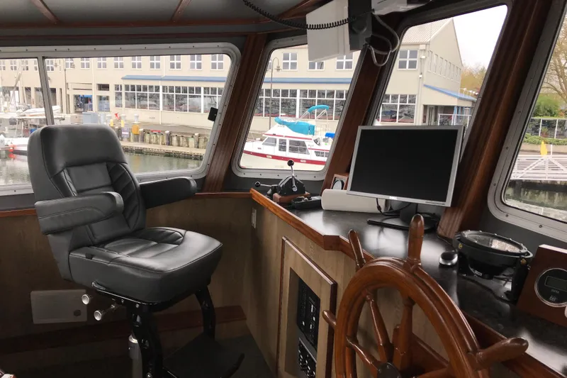  Yacht Photos Pics Interior of 1973 Custom 58&rsquo; Steel Marco Seiner with helm, chair, and navigation equipment.