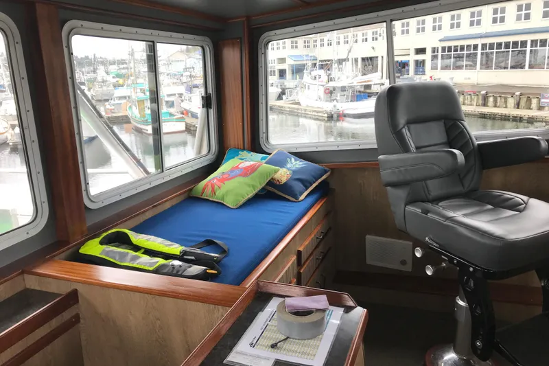  Yacht Photos Pics Interior of 1973 Custom 58&rsquo; Steel Marco Seiner with bed, chair, and marina view.