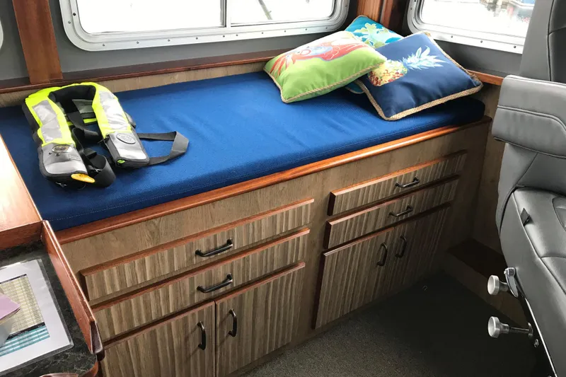  Yacht Photos Pics Interior of 1973 Custom 58&rsquo; Steel Marco Seiner with blue cushioned bench and life jacket.
