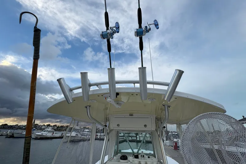 Plan B Yacht Photos Pics 2006 Regulator 32 Forward Seating boat with fishing rods and rod holders, docked under cloudy sky.