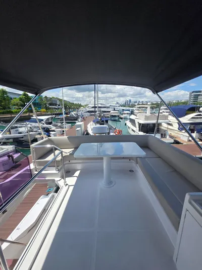 Ferretti Yachts 500 Yacht Photos Pics 2022 Ferretti Yachts 500, spacious deck view at marina, under canopy, surrounded by boats.