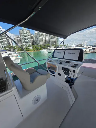 Ferretti Yachts 500 Yacht Photos Pics 2022 Ferretti Yachts 500 helm with modern controls, docked in a marina with cityscape view.