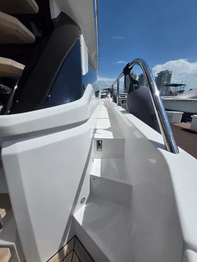 Ferretti Yachts 500 Yacht Photos Pics 2022 Ferretti Yachts 500 side deck view with railing, city skyline in background.