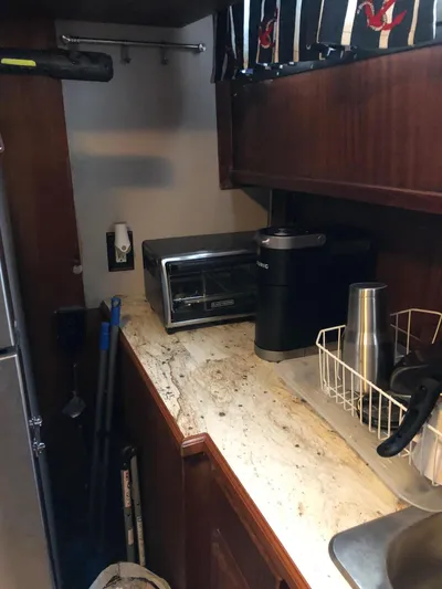  Yacht Photos Pics Compact kitchen area in a 1980 Hatteras 53 Motor Yacht with appliances and countertop.