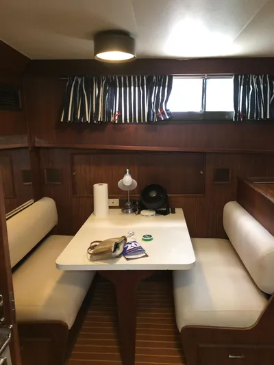  Yacht Photos Pics Interior of 1980 Hatteras 53 Motor Yacht with cozy dining area and striped curtains.