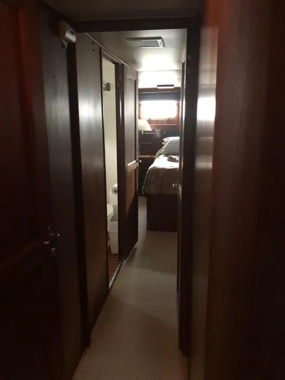  Yacht Photos Pics Narrow hallway inside 1980 Hatteras 53 Motor Yacht, leading to a bedroom with wooden interior.