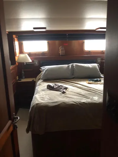  Yacht Photos Pics Cozy bedroom in 1980 Hatteras 53 Motor Yacht with wooden interior and natural light.