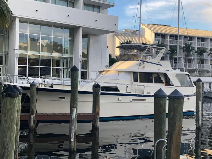  Yacht Photos Pics 1980 Hatteras 53 Motor Yacht docked near modern waterfront buildings.