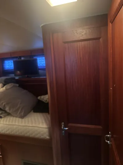  Yacht Photos Pics Interior cabin of 1980 Hatteras 53 Motoryacht with wooden door and cozy bedding.