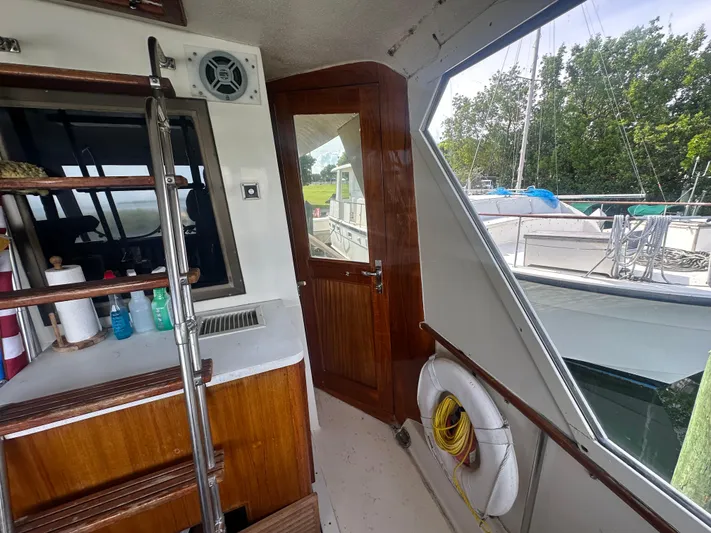  Yacht Photos Pics Interior view of 1980 Hatteras 53 Motoryacht with wooden door, ladder, and cleaning supplies.
