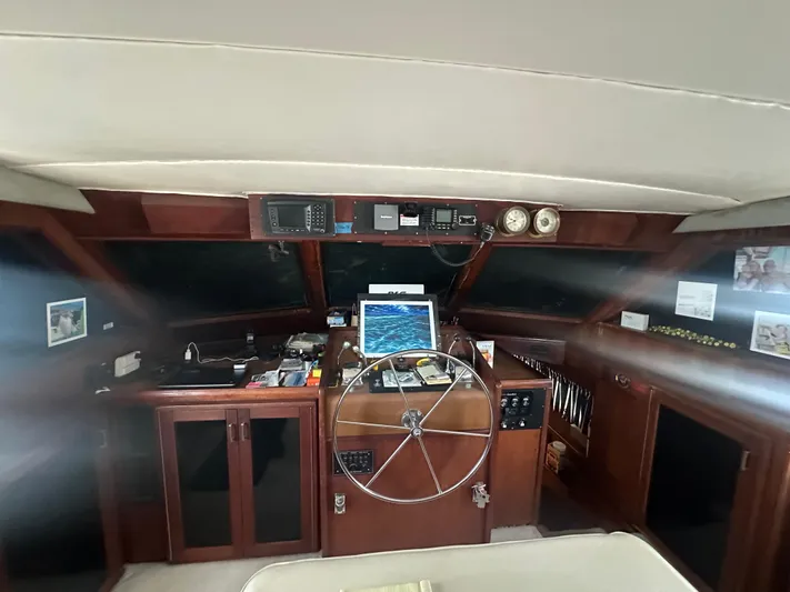  Yacht Photos Pics 1980 Hatteras 53 Motoryacht helm with steering wheel, navigation equipment, and wood paneling.