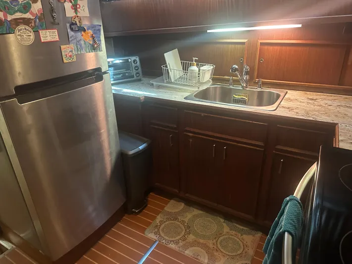  Yacht Photos Pics Kitchen area of 1980 Hatteras 53 Motoryacht with stainless steel appliances and wooden cabinetry.