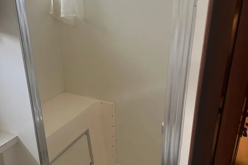  Yacht Photos Pics Interior of 1980 Hatteras 53 Motoryacht, featuring a compact, white-walled space with a small window.