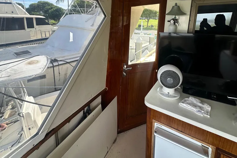  Yacht Photos Pics Interior view of 1980 Hatteras 53 Motoryacht with TV, fan, and wooden door.