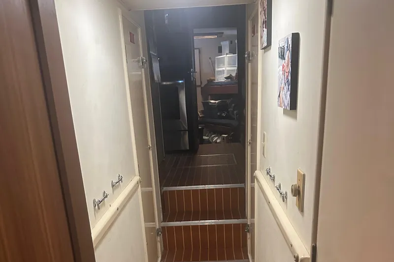  Yacht Photos Pics Interior hallway of a 1980 Hatteras 53 Motoryacht with wooden flooring and wall decor.