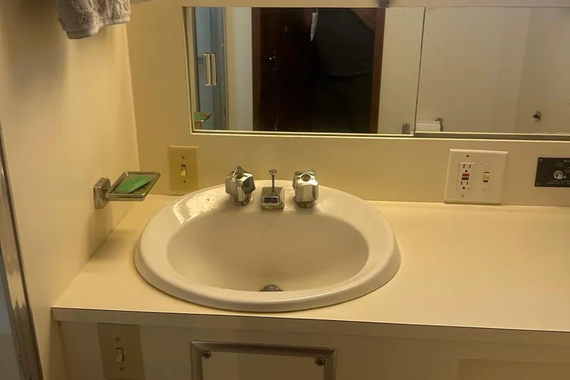  Yacht Photos Pics Bathroom sink area on a 1980 Hatteras 53 Motoryacht, featuring a mirror and soap holder.