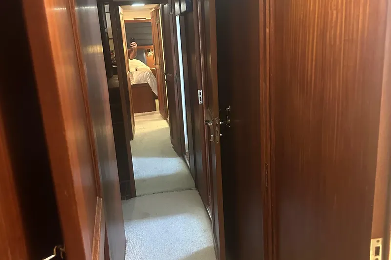  Yacht Photos Pics Interior hallway of 1980 Hatteras 53 Motoryacht with wooden paneling and carpeted floor.