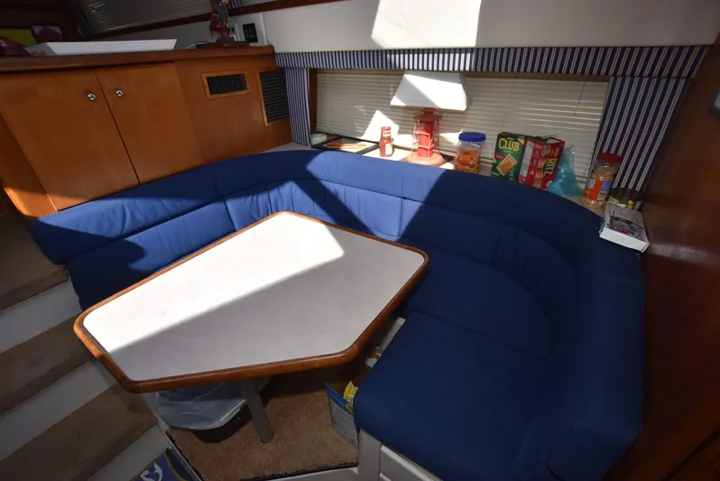 Miss Dot Yacht Photos Pics 1997 Carver 405 Aft Cabin Motoryacht interior with blue seating and dining table.