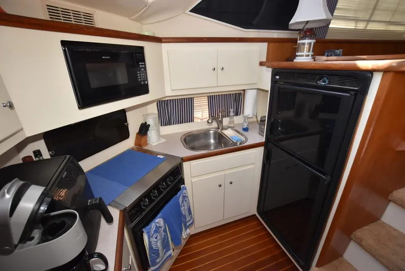 Miss Dot Yacht Photos Pics 1997 Carver 405 Aft Cabin Motoryacht kitchen with appliances and wooden flooring.
