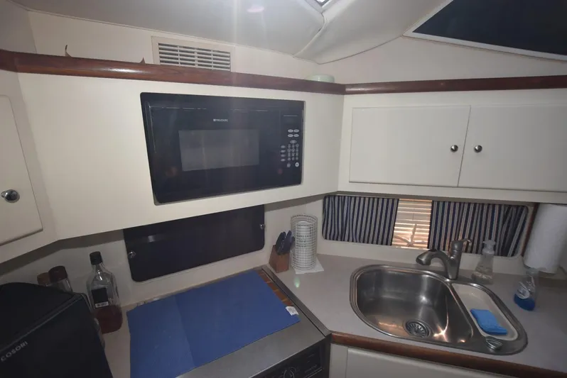 Miss Dot Yacht Photos Pics 1997 Carver 405 Aft Cabin Motoryacht kitchen with microwave, sink, and storage cabinets.