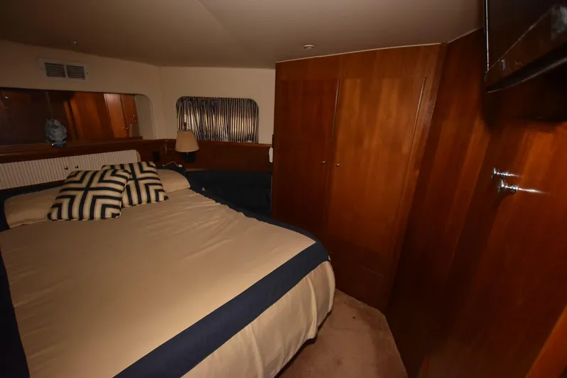 Miss Dot Yacht Photos Pics 1997 Carver 405 Aft Cabin Motoryacht bedroom with wood paneling and cozy bedding.