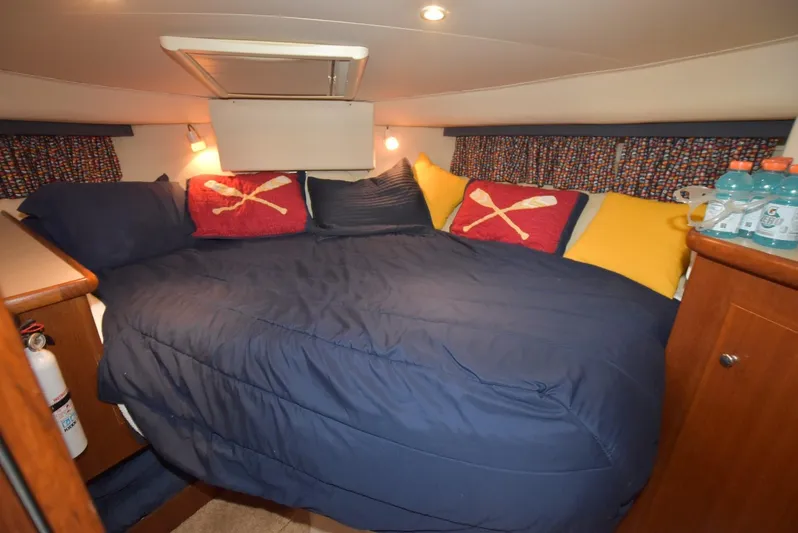 Miss Dot Yacht Photos Pics Cozy bedroom in 1997 Carver 405 Aft Cabin Motoryacht with blue bedding and colorful pillows.