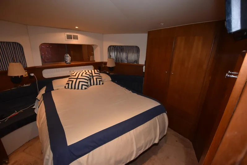 Miss Dot Yacht Photos Pics 1997 Carver 405 Aft Cabin Motoryacht bedroom with cozy bed and wooden cabinetry.