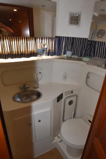 Miss Dot Yacht Photos Pics 1997 Carver 405 Aft Cabin Motoryacht bathroom with sink, toilet, and striped curtain.