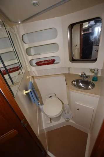 Miss Dot Yacht Photos Pics 1997 Carver 405 Aft Cabin Motoryacht bathroom with sink, toilet, and mirror.