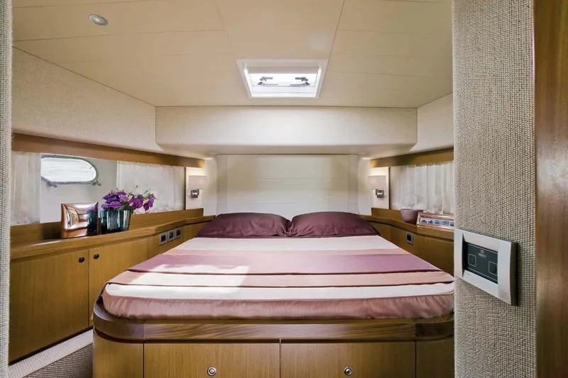  Yacht Photos Pics Luxurious bedroom interior of 2009 Ferretti Yachts 681 with elegant wood finishes.