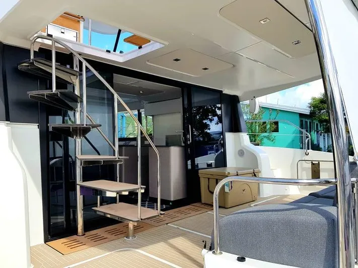 Calypso Yacht Photos Pics 2021 Fountaine Pajot MY6 yacht interior with spiral staircase and modern seating area.