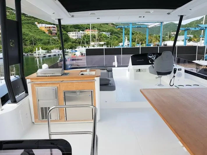 Calypso Yacht Photos Pics Luxury 2021 Fountaine Pajot MY6 yacht deck with modern amenities and scenic marina view.