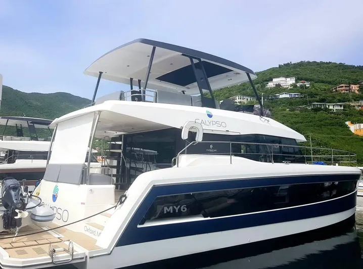 Calypso Yacht Photos Pics 2021 Fountaine Pajot MY6 yacht docked in a scenic marina.