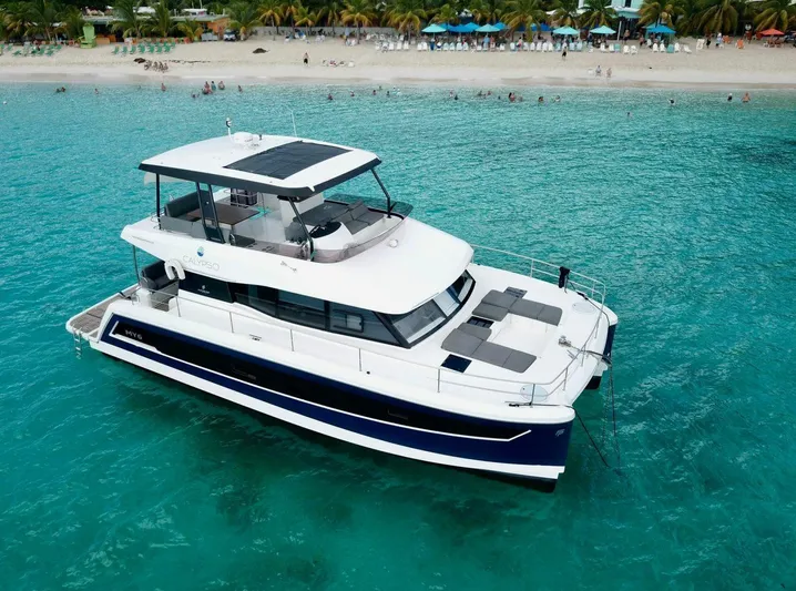 Calypso Yacht Photos Pics 2021 Fountaine Pajot MY6 yacht anchored in turquoise waters near a sandy beach.