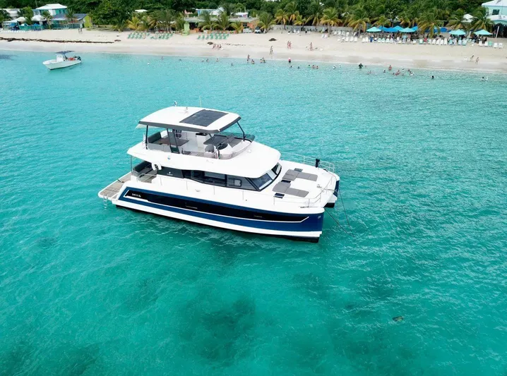 Calypso Yacht Photos Pics 2021 Fountaine Pajot MY6 yacht cruising in turquoise waters near a sandy beach.