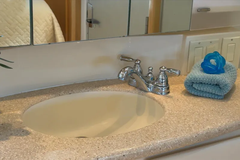 Cape San Blas Inn Yacht Photos Pics Bathroom sink area in 1998 Carver 455 Aft Cabin Motor Yacht, featuring chrome faucet and folded towel.