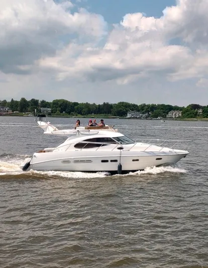  Yacht Photos Pics 2003 Sealine F425 yacht cruising on a scenic river under a partly cloudy sky.