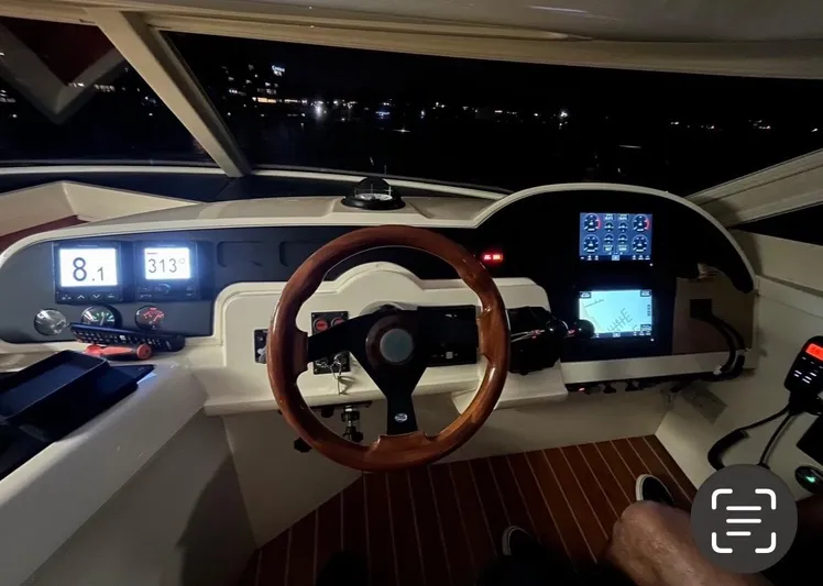  Yacht Photos Pics Cockpit of 2003 Sealine F425 yacht with illuminated dashboard and wooden steering wheel.