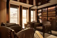 Luxurious interior of a 2026 custom motor yacht with leather seating and ocean view.