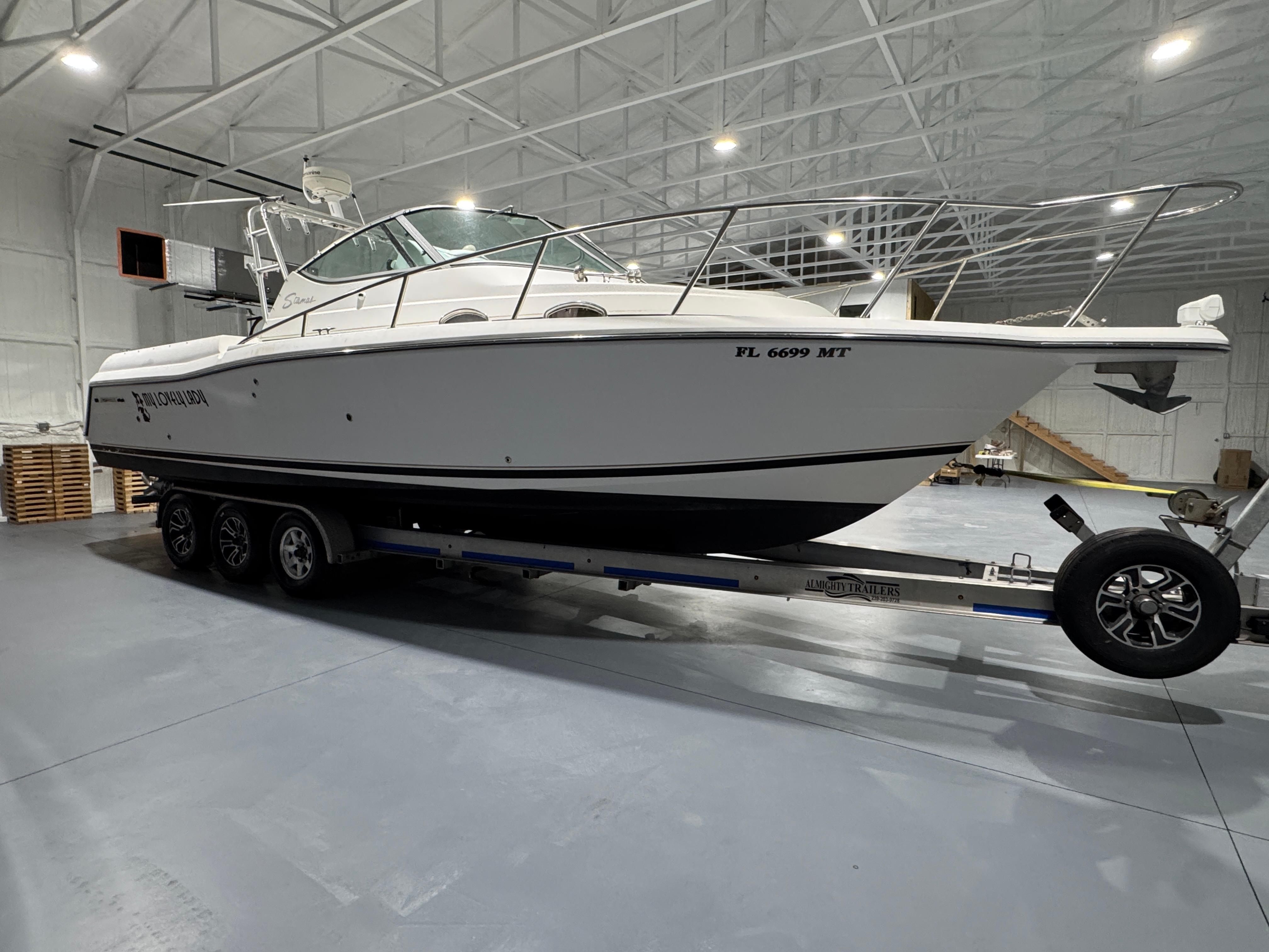 2005 Stamas 310 Express boat on trailer in indoor storage facility.