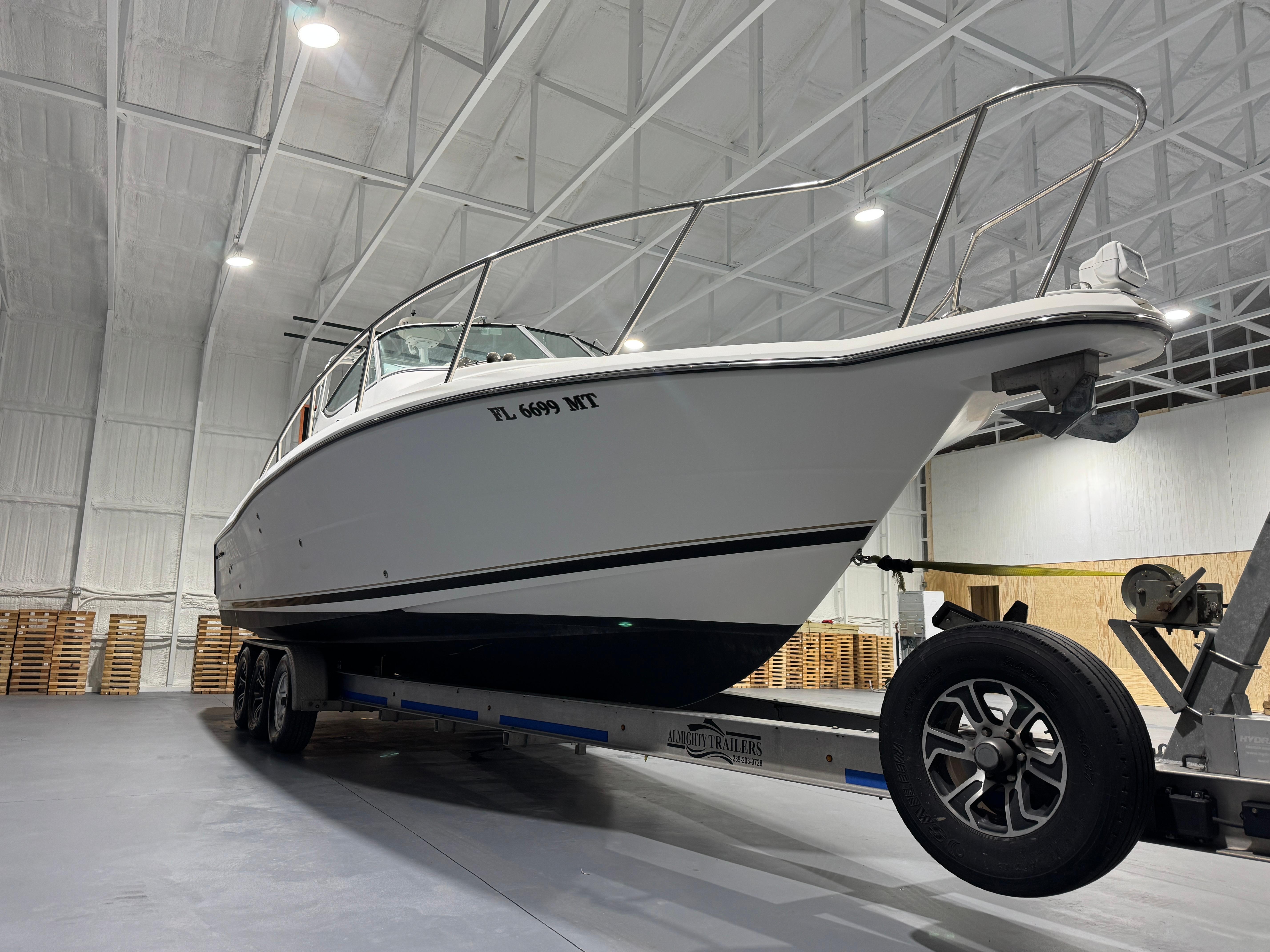 2005 Stamas 310 Express boat on trailer in indoor storage facility.
