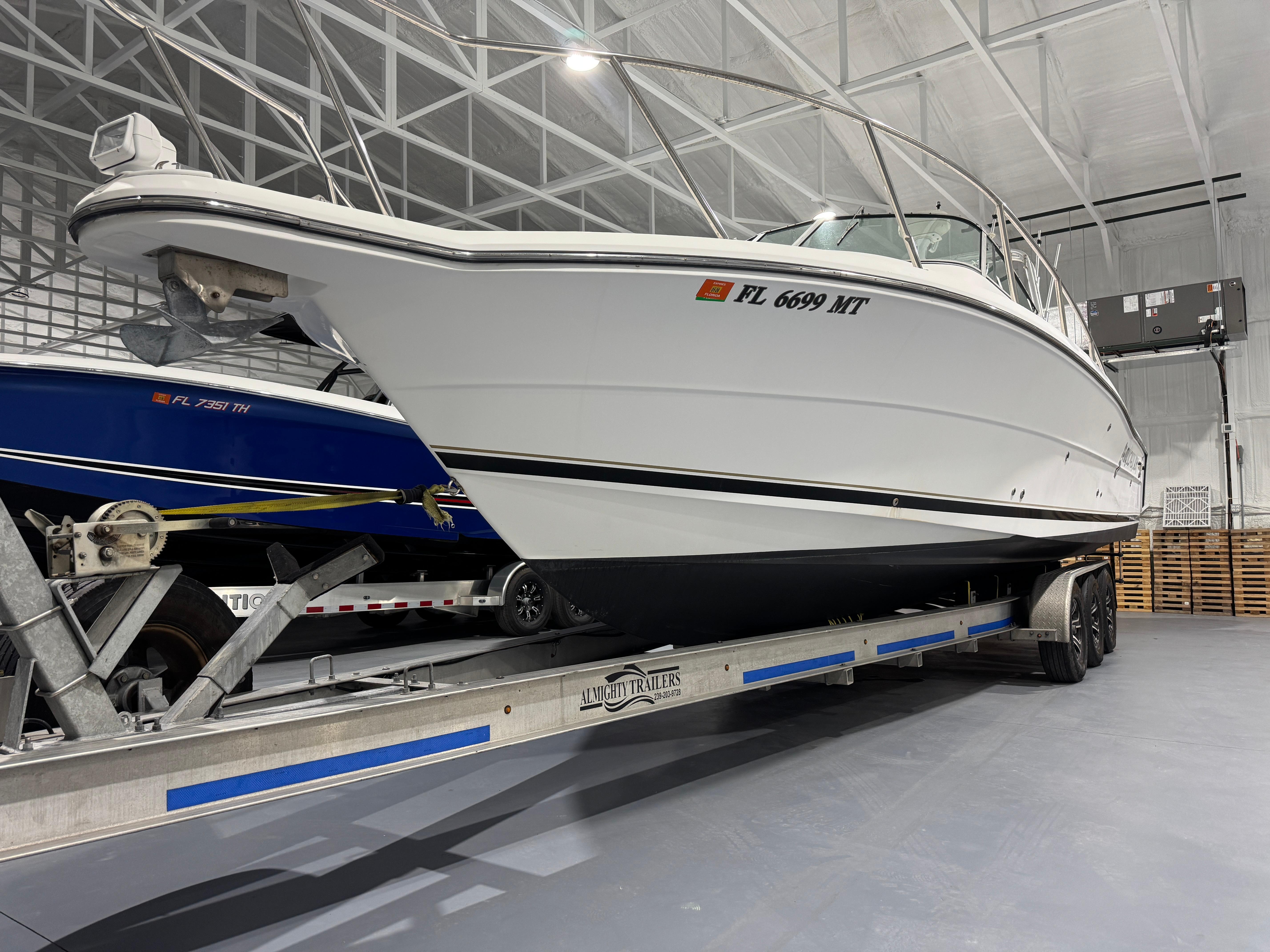2005 Stamas 310 Express boat on trailer in indoor storage facility.