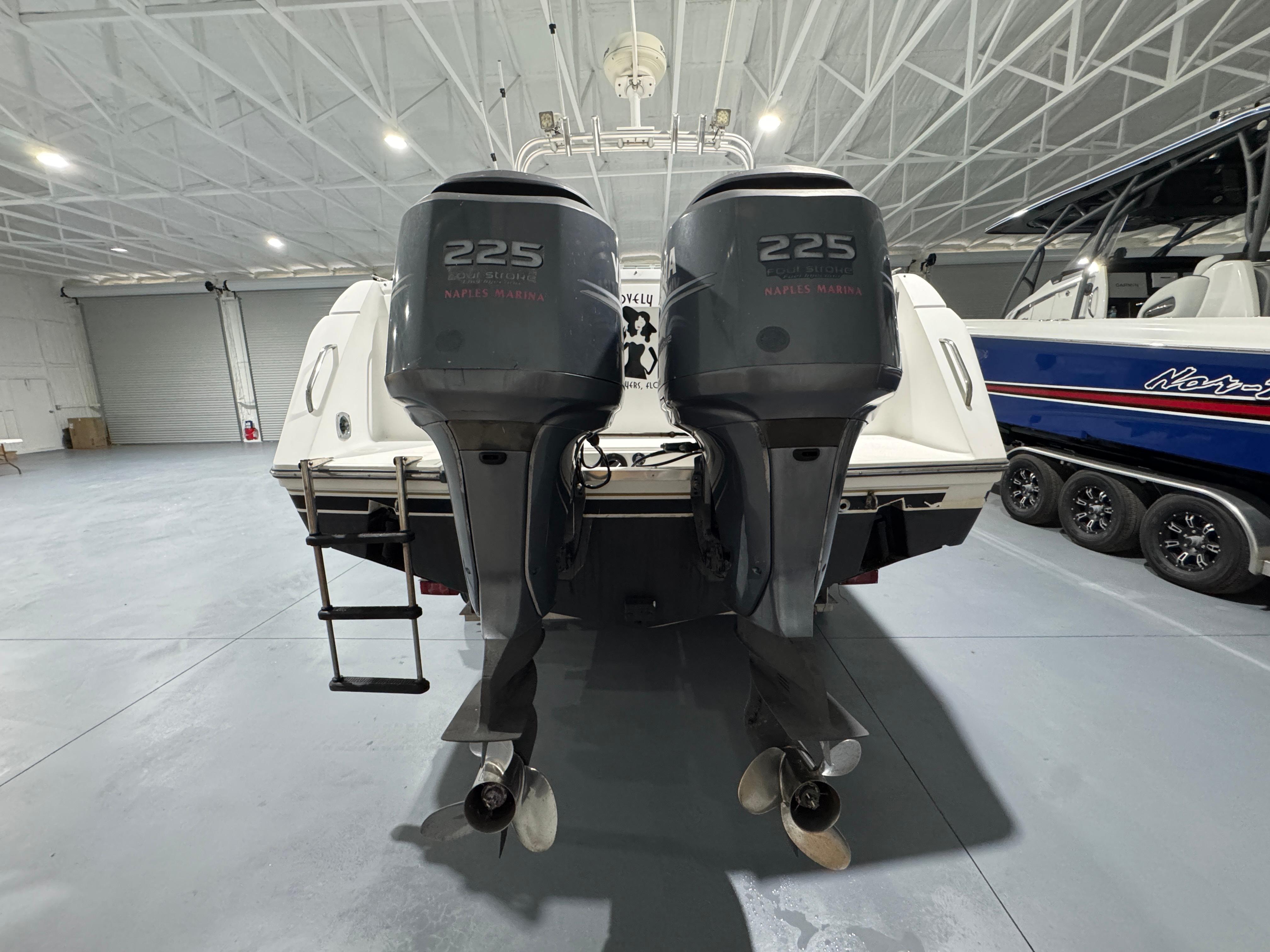 2005 Stamas 310 Express boat with twin 225 horsepower engines in a spacious indoor marina.