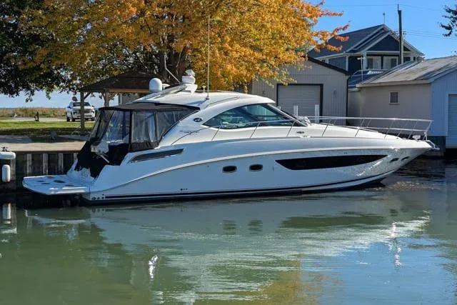 Nautalia Yacht Photos Pics 2013 Sea Ray 470 Sundancer yacht docked by autumn trees and waterfront buildings.