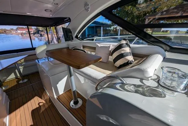 Nautalia Yacht Photos Pics Luxurious interior of 2013 Sea Ray 470 Sundancer yacht with elegant seating and wooden table.