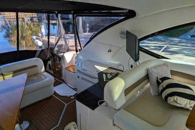 Nautalia Yacht Photos Pics Interior of 2013 Sea Ray 470 Sundancer yacht with seating, table, and TV.